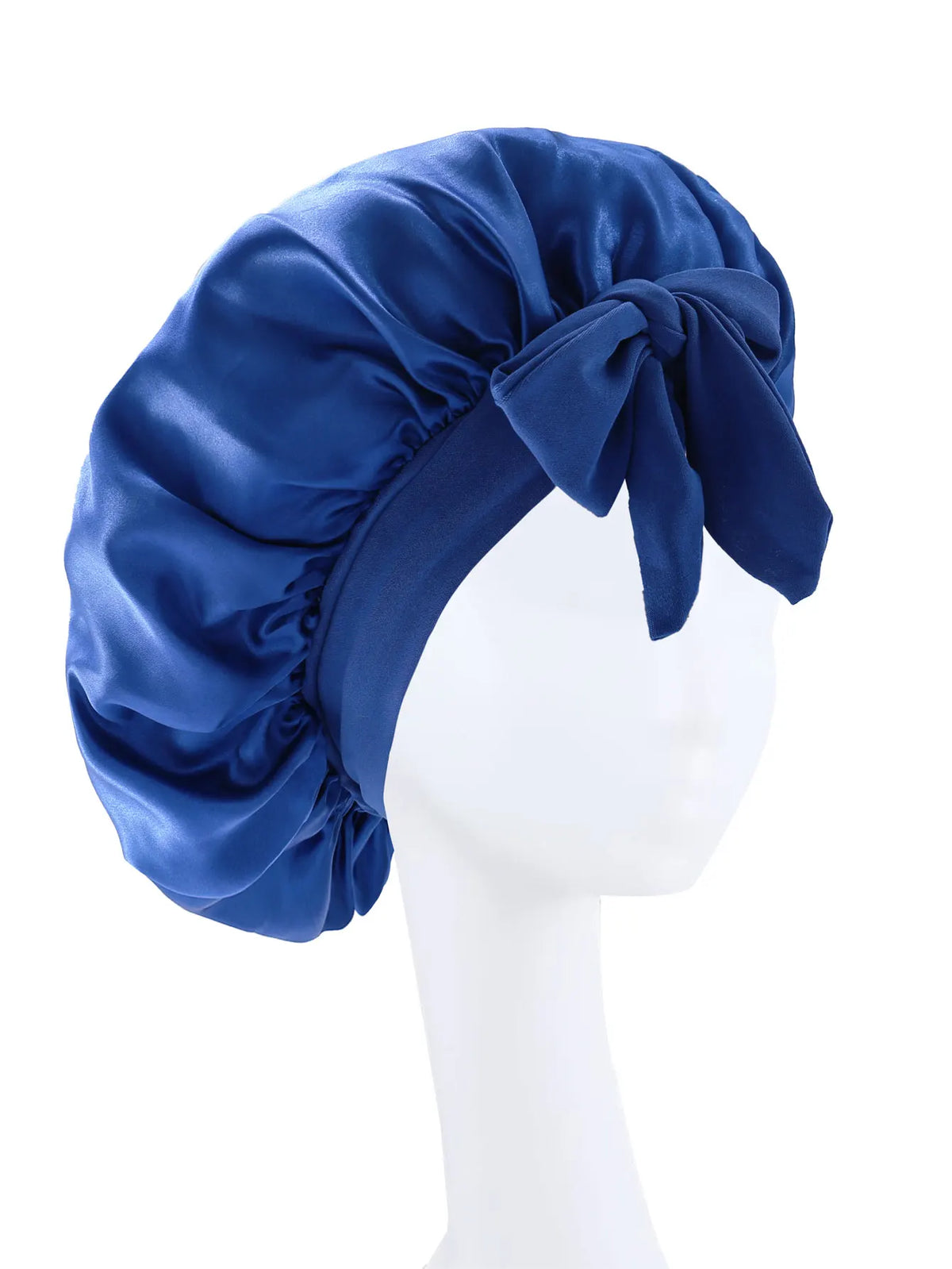 A deep blue silky satin sleep bonnet tied in a bow, displayed on a white mannequin head.