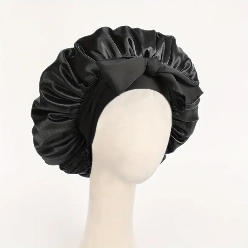 Schwarzer Seiden-Haube aus Satin, gebunden in eine Schleife, auf einem Mannequin-Kopf