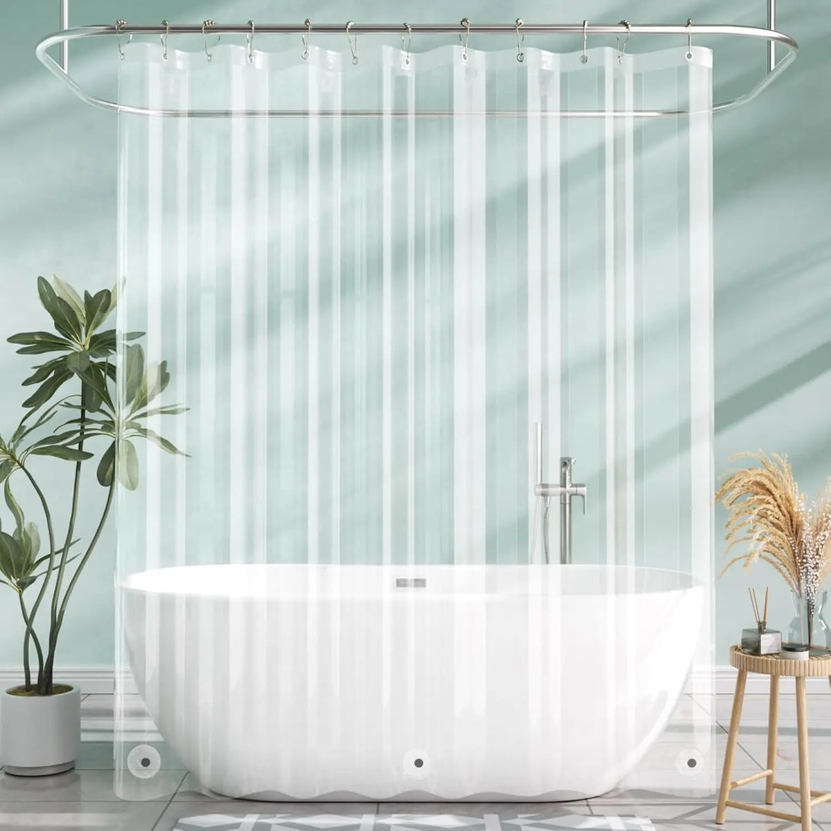A crystal clear shower curtain with weighted magnets hanging over a white bathtub in a bathroom.