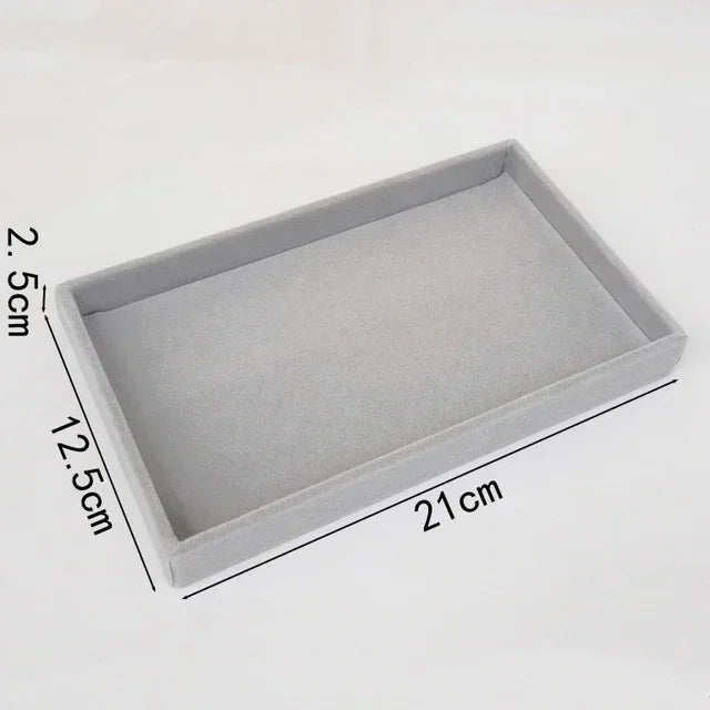 A rectangular velvet jewelry organizer tray with a soft lining, shown from above.