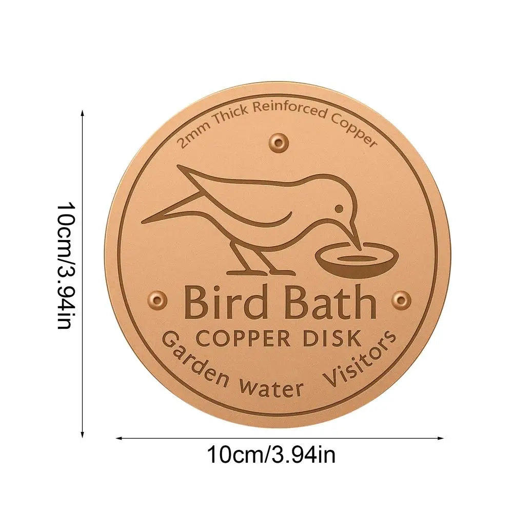 A round copper disk bird bath for garden water with a silhouette of a bird on it.