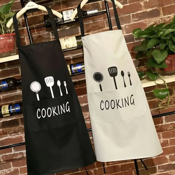 A black and white chef's apron hanging on a rack against a brick wall.