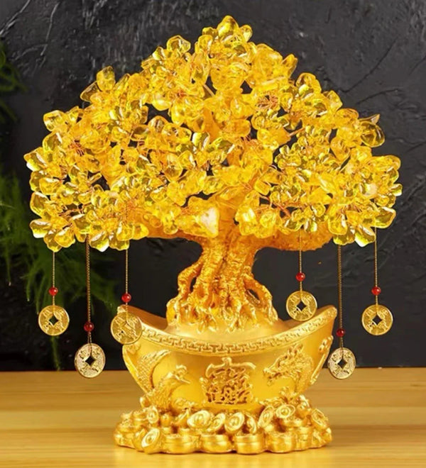 Golden crystal prosperity tree sculpture with hanging elements on a wooden surface.