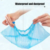 A hand is holding a clear blue waterproof plastic shoe cover, demonstrating its protective qualities.