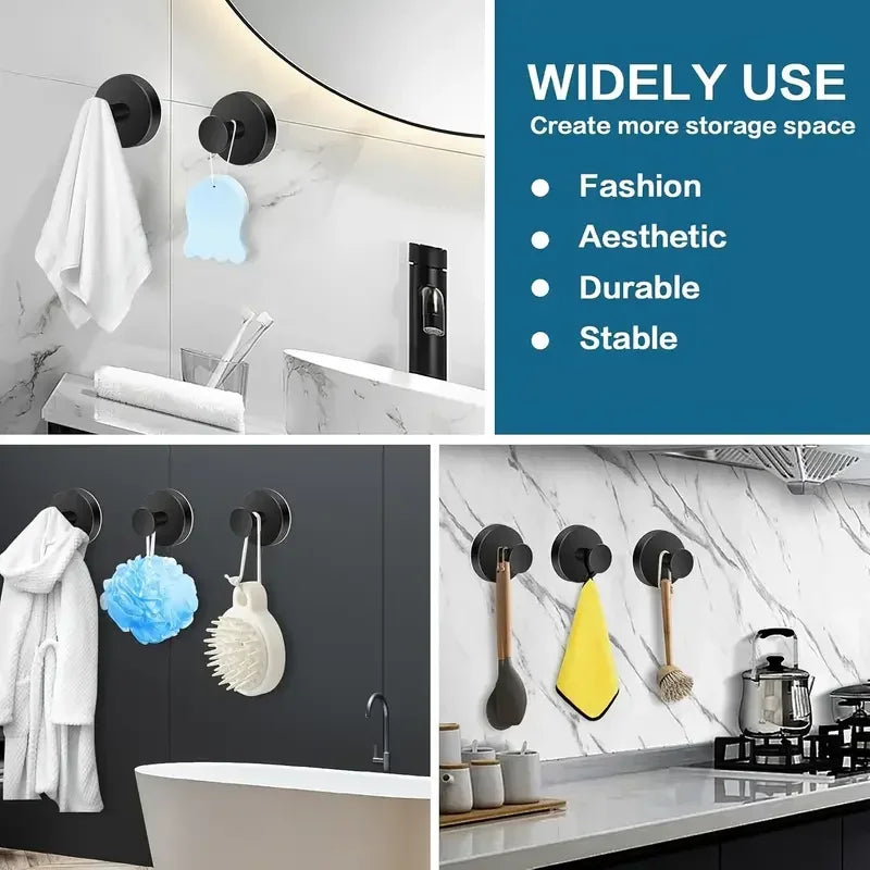 A set of reusable suction cup hooks in black and white mounted on a wall, used for hanging items like towels or accessories.
