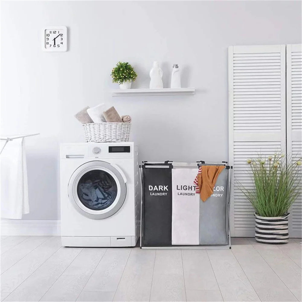 Un panier à linge blanc pliable à côté d'une machine à laver blanche sur un sol gris clair.