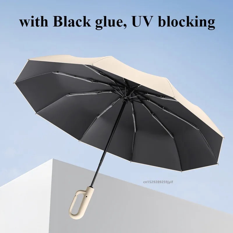 A black umbrella with a beige canopy is shown open against a light blue sky.