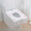 A white toilet seat covered with a pink flamingo patterned disposable printing seat cover.