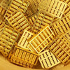 A pile of small, rectangular gold bar decorative ornaments.