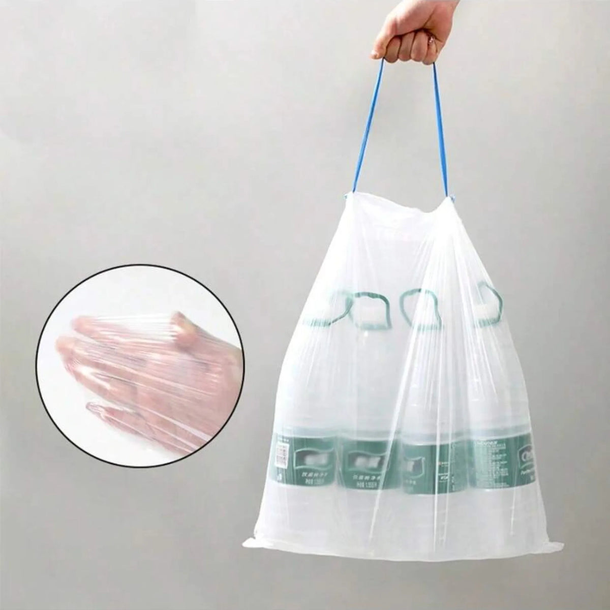 A hand holds a white drawstring trash bag with green scent labels, showing the product.