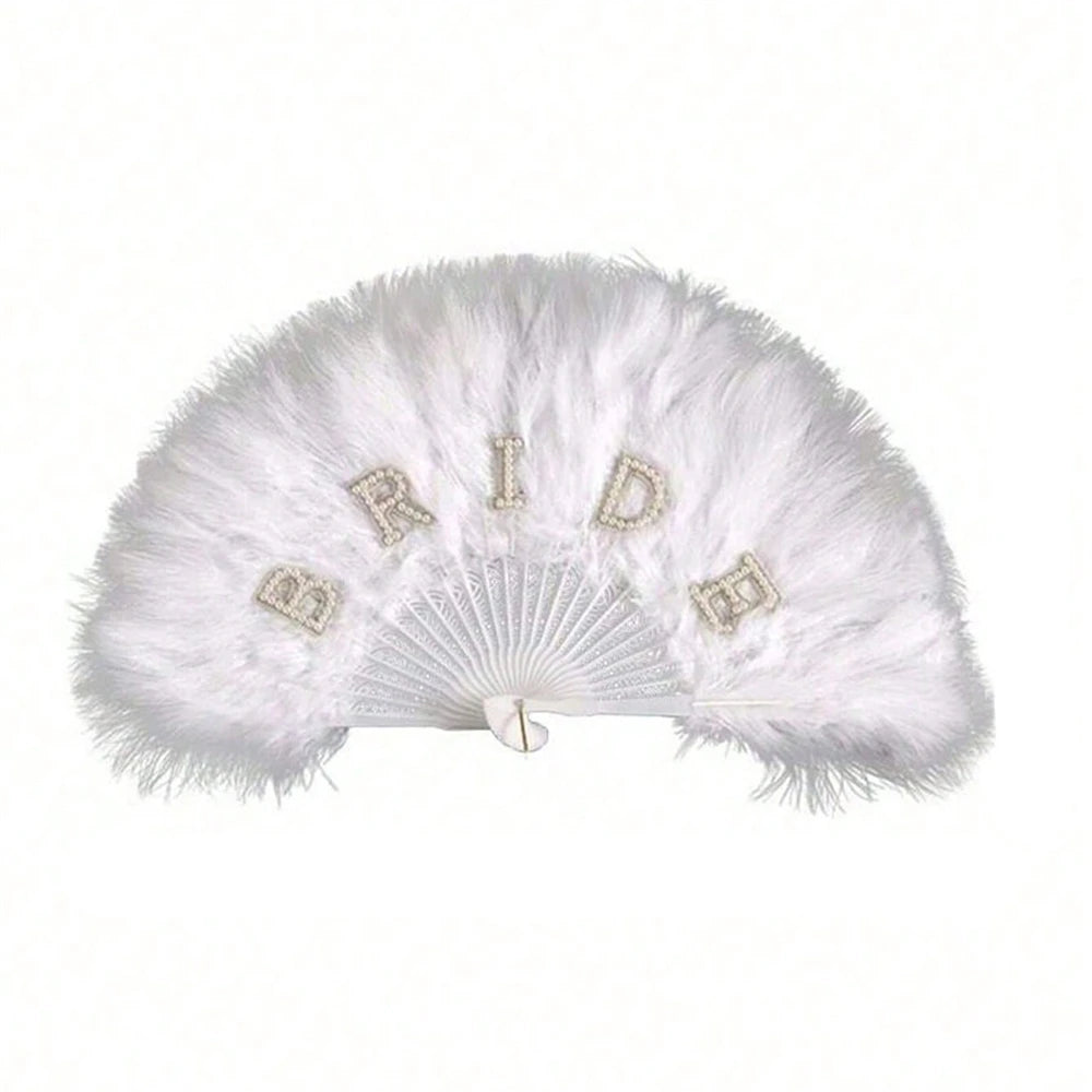 A white feather hand fan with the word bride spelled out in small embellishments for bridal decor.