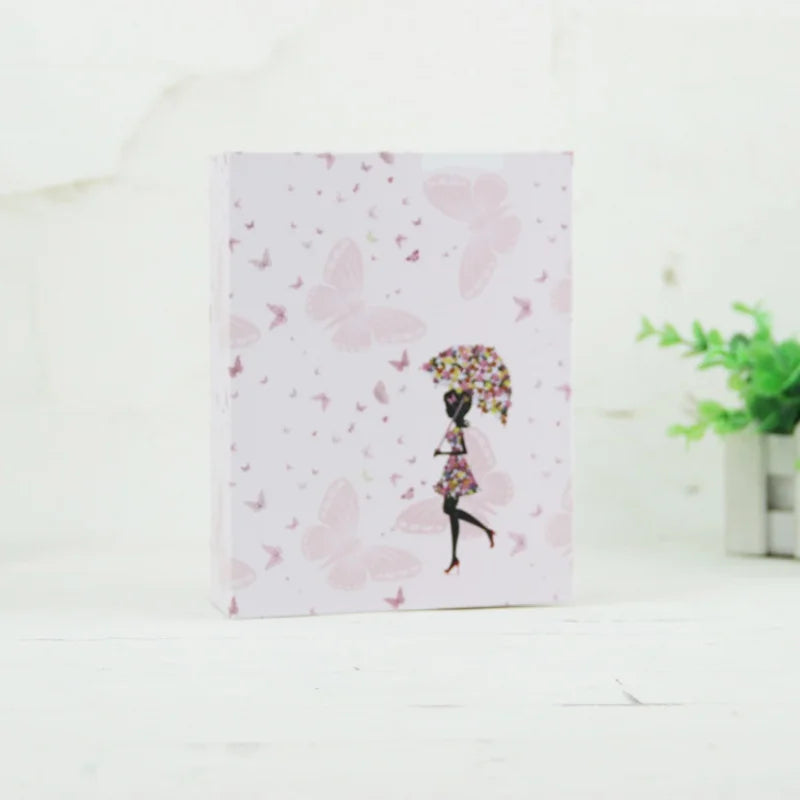 Álbum de fotos rosa con patrones de mariposa y silueta de una persona bailando.