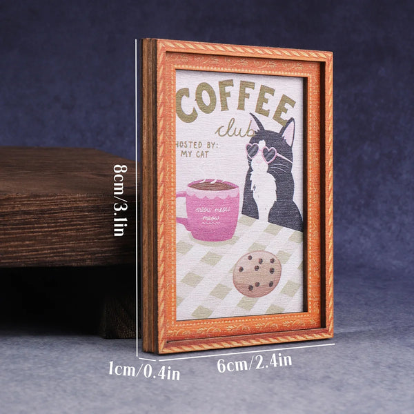 A framed print featuring a black and white cat illustration with the text Coffee Club hosted by My Cat