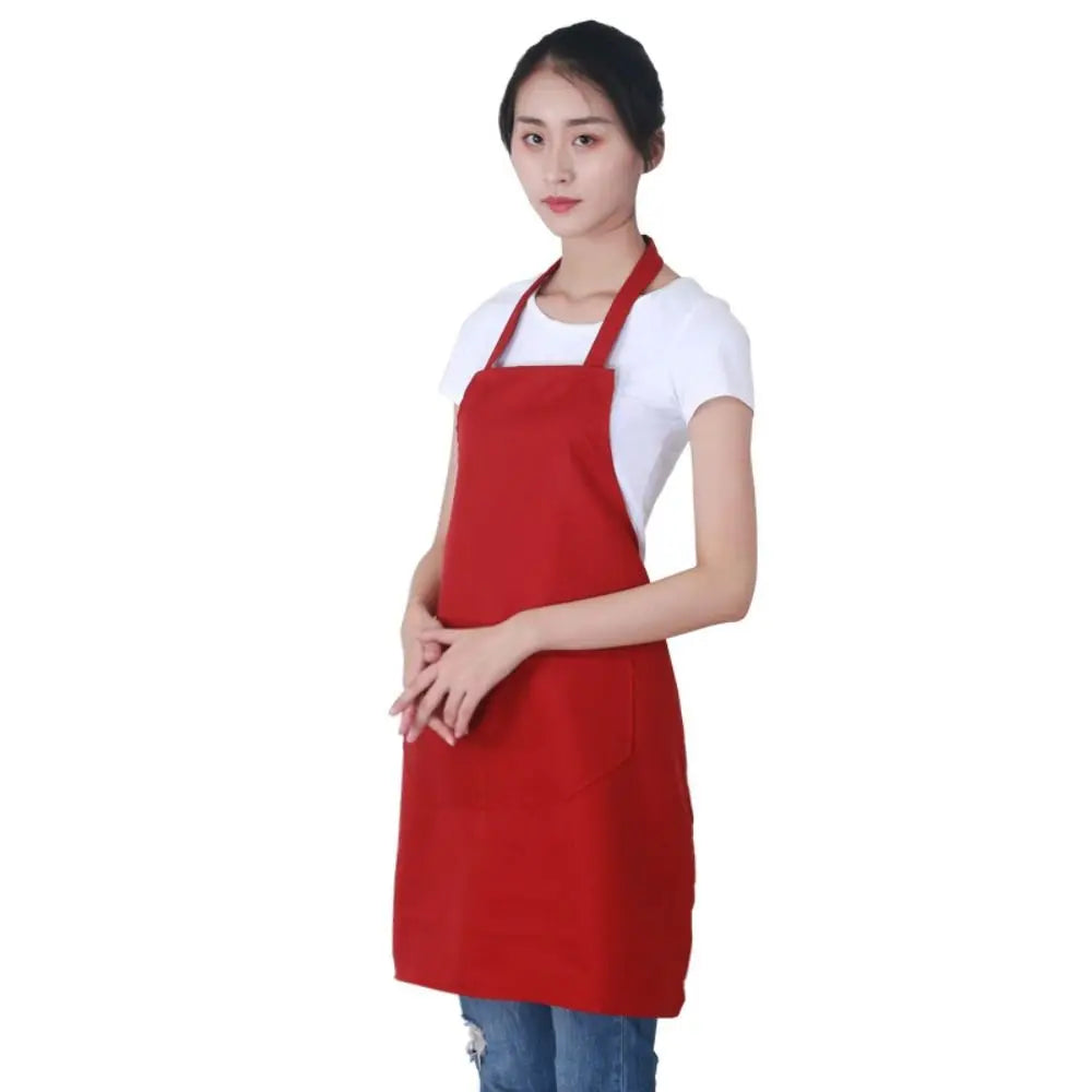 A woman wearing a red oil-proof cooking apron over a white shirt.