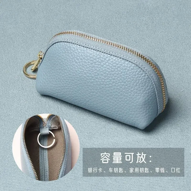A light blue leather key organizer wallet with a zipper closure shown against a muted background.