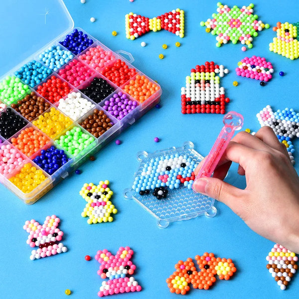 A hand holds a clear tray of blue crystal beads surrounded by various colorful plastic beads for crafting and sensory play.