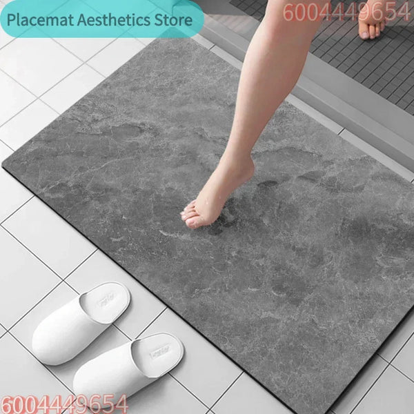 A white diatomite eco-friendly non-slip bath mat is shown being used on a gray tile floor.