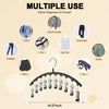 Percha de acero inoxidable negro con múltiples clips, usada como organizador de pantalones para un armario.