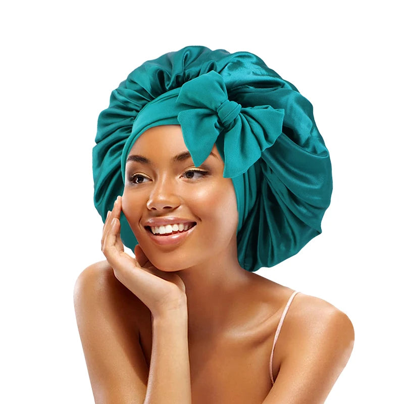 A woman wearing a teal satin sleeping cap tied in a bow, looking to the side.