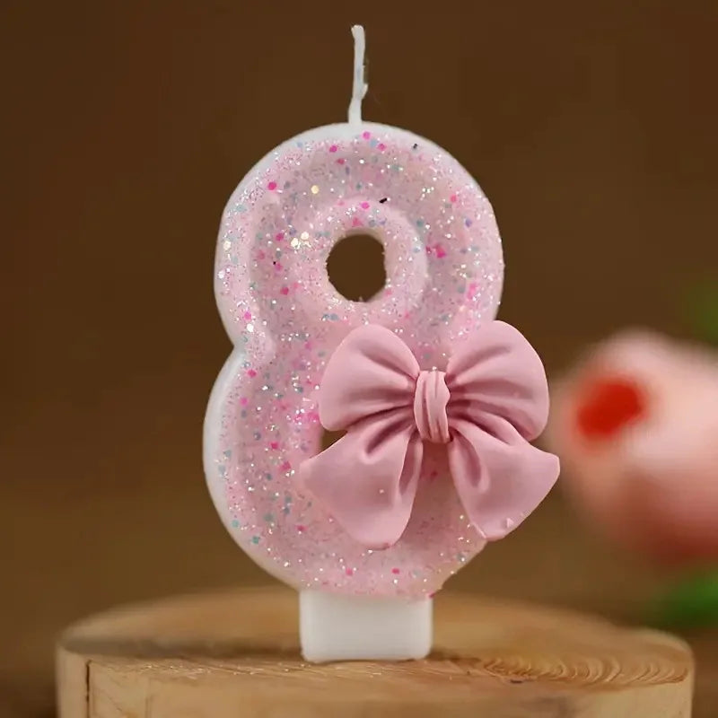 Pink glitter number eight candle with a pink bow on a white base