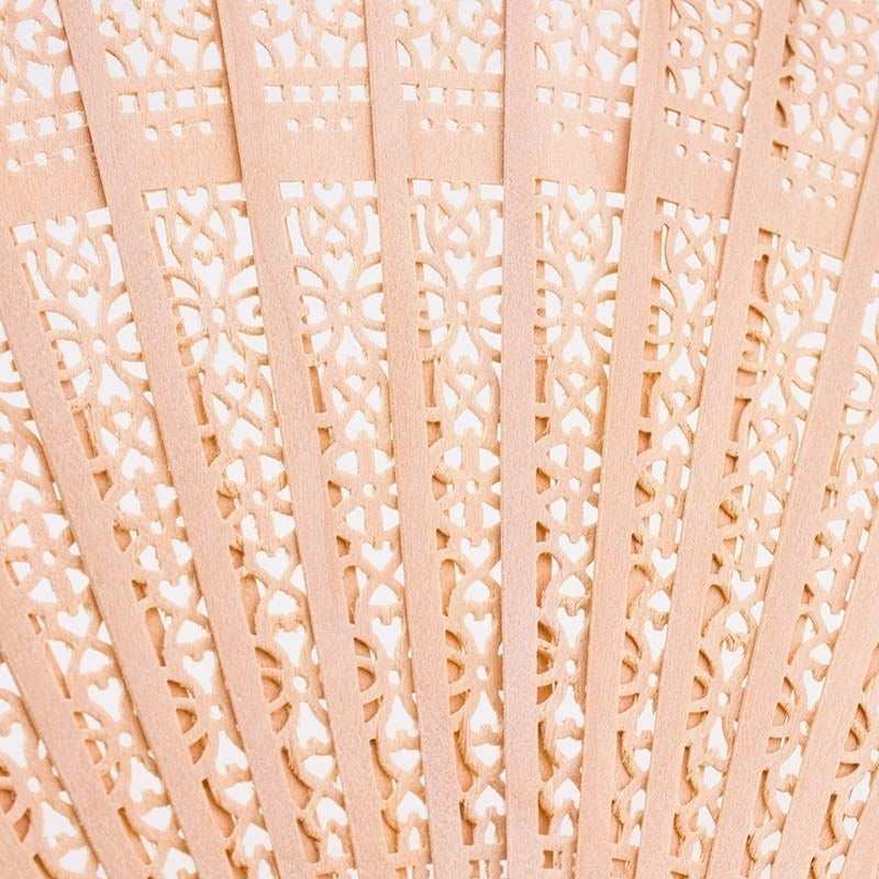 Ventilateur pliable rose pâle en bois de santal avec des motifs découpés complexes