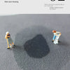 A dark shadow is cast on a gray surface by small figures, demonstrating the water absorption of the mud floor mat.