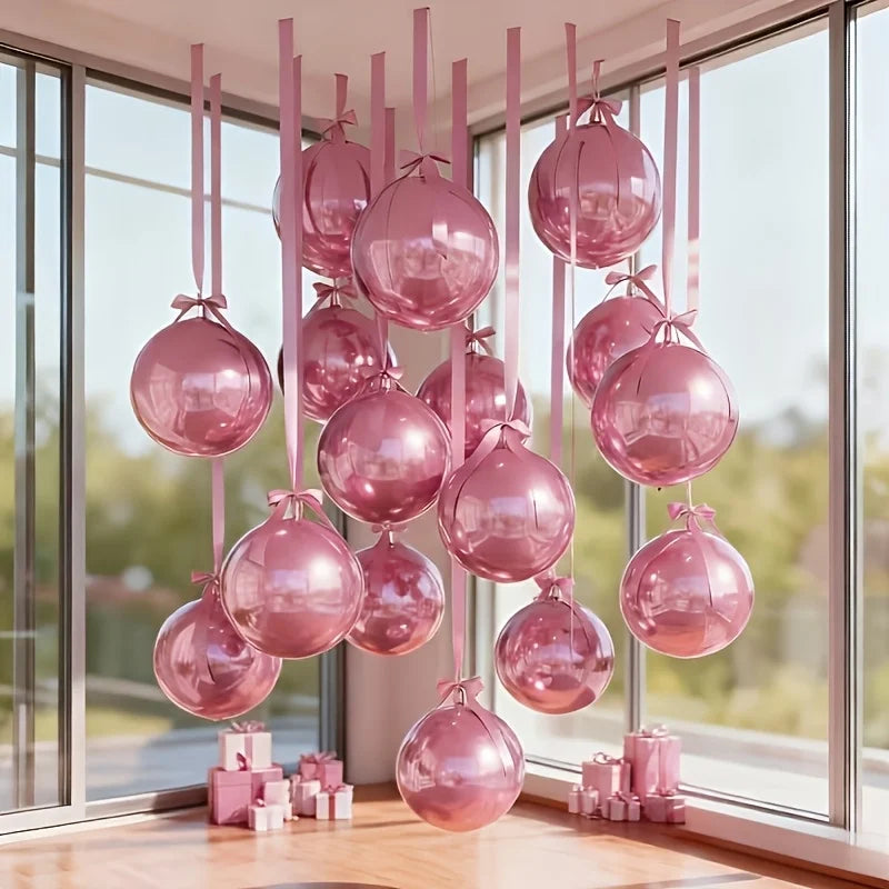 Una colección de diez globos metálicos rosados suspendidos frente a una gran ventana.