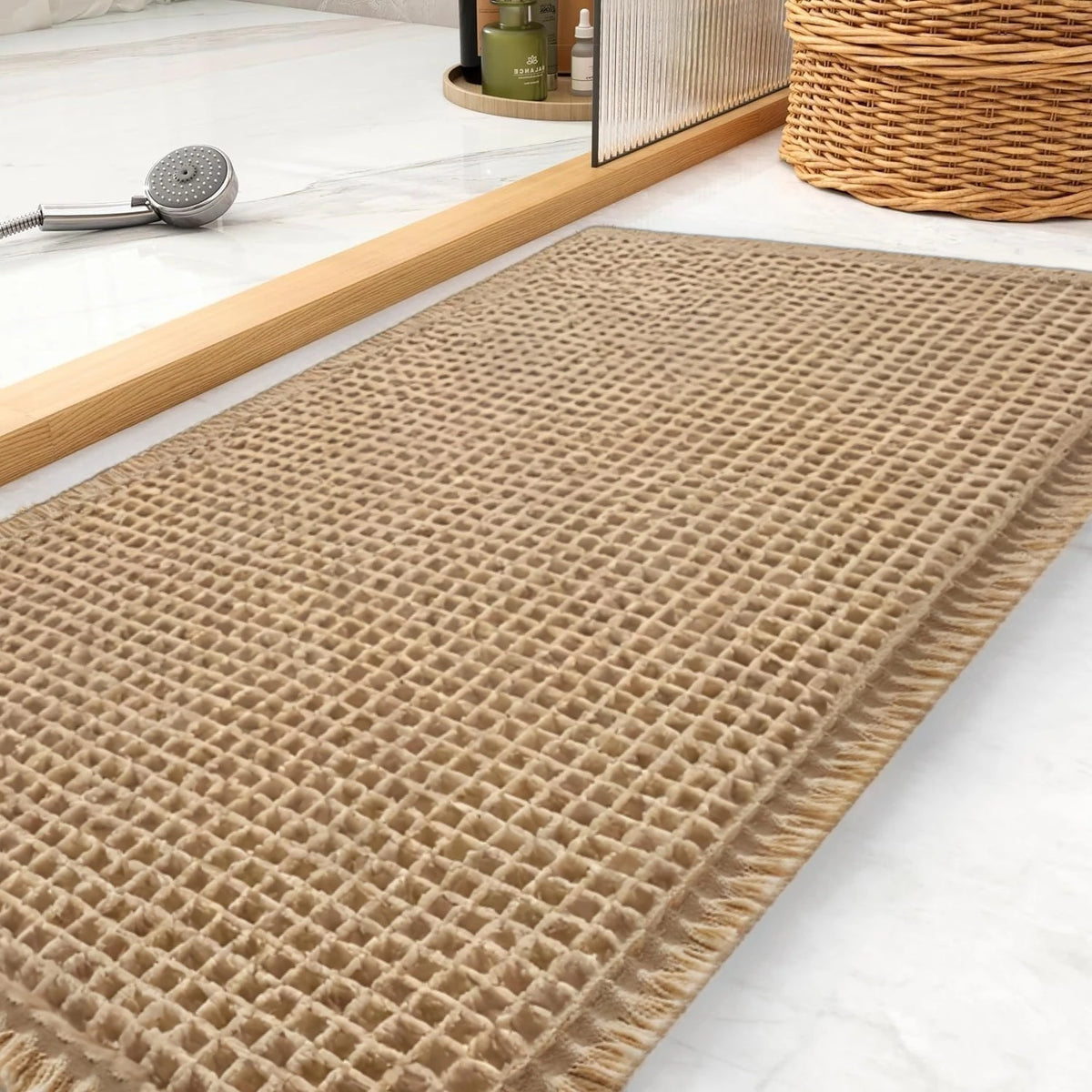 A rectangular beige waffle texture non-slip bath mat is displayed on a white marble surface.