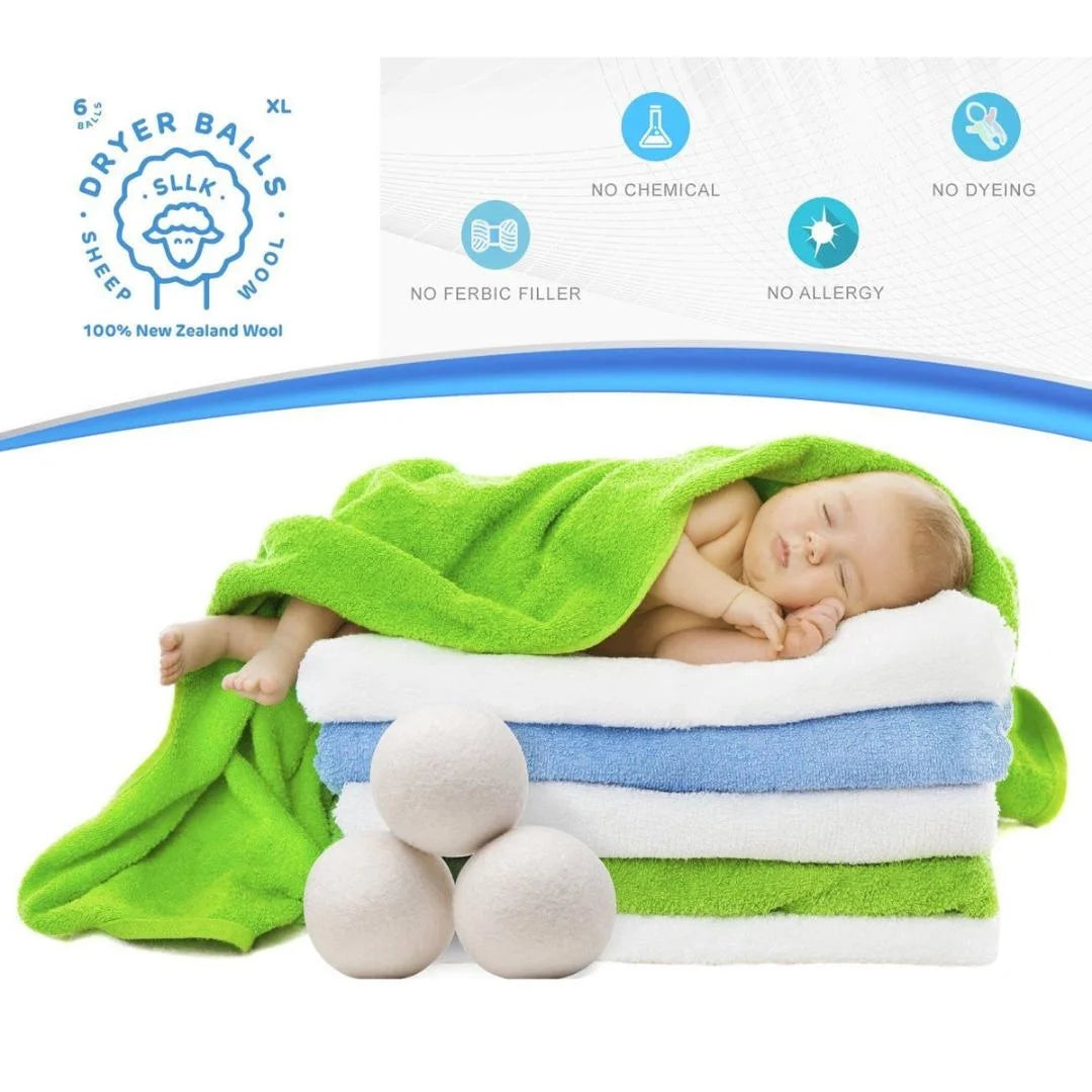A newborn baby sleeping on a stack of green and white reusable wool dryer balls for clothes drying.