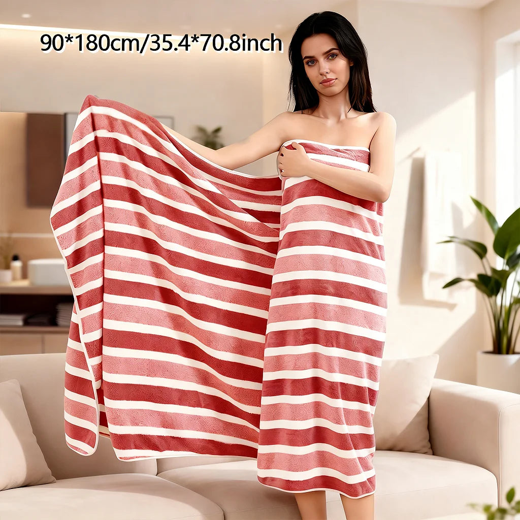 A woman models a coral fleece bath towel draped over her body in a striped pattern.
