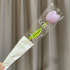 Bouquet de cœurs à la main en coton avec une fleur violette et une tige verte, présenté dans une gaine en plastique transpare