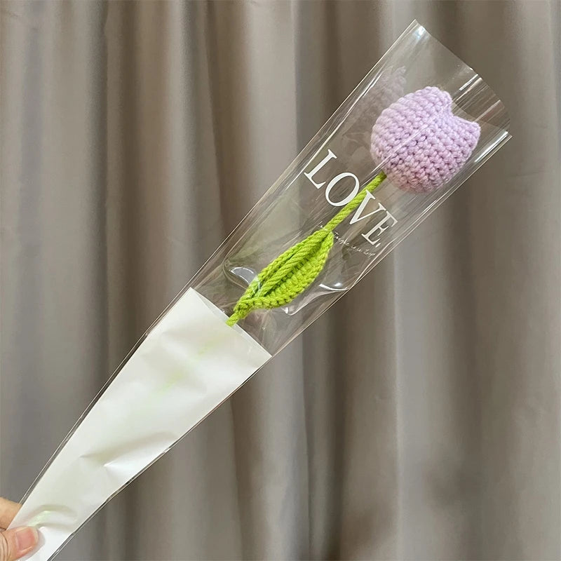 Bouquet de cœurs à la main en coton avec une fleur violette et une tige verte, présenté dans une gaine en plastique transpare