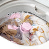 A white laundry mesh filter bag filled with pink and white lint and hair.