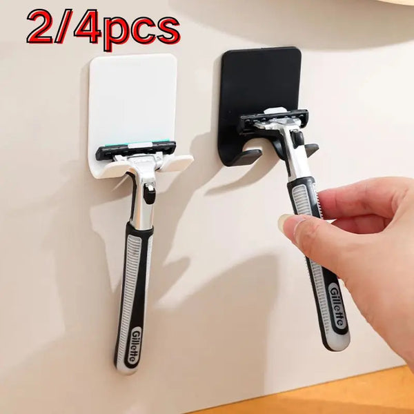 Two wall-mounted razor holders, one white and one black, are shown being held by a hand.