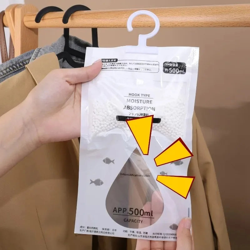 A hand holds a white plastic bag of moisture absorption packets for a hanging dehumidifier.