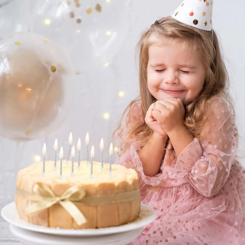 Ein junges Mädchen mit langen Haaren lächelt und hält einen Kuchen mit brennenden Kerzen vor sich.