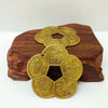 A set of traditional copper feng shui coins with intricate designs resting on a dark wooden surface.
