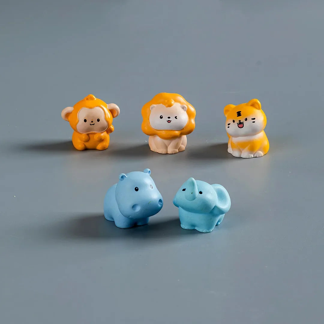 A set of three mini resin cartoon animal figurines: a yellow lion cub, an orange lion, and a yellow cat.