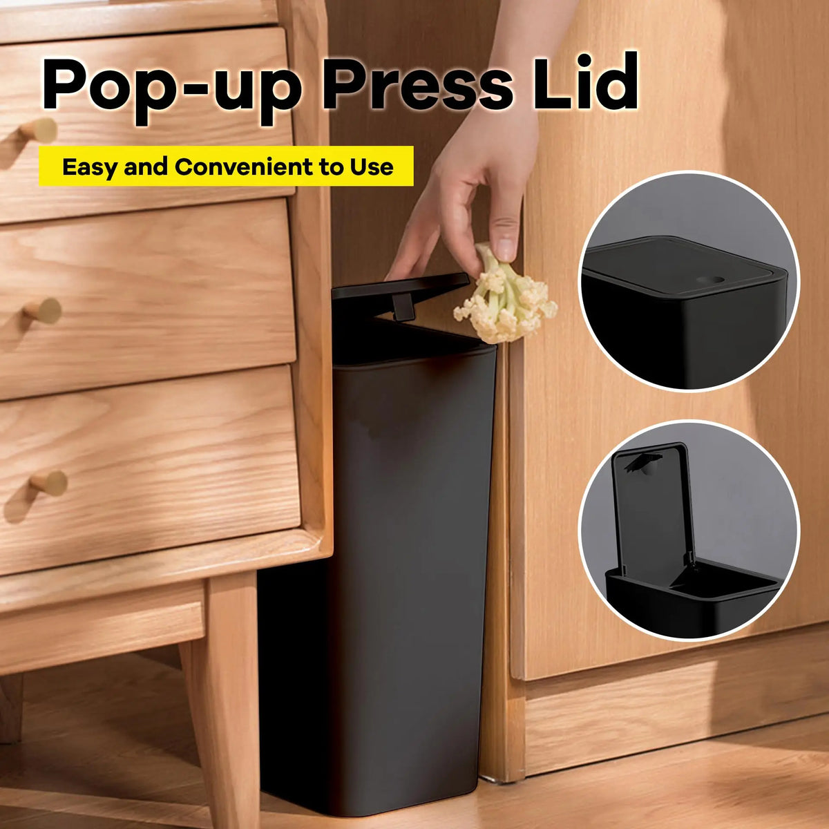 A hand is pressing a pop-up press lid onto a black trash can in a wooden cabinet setting.