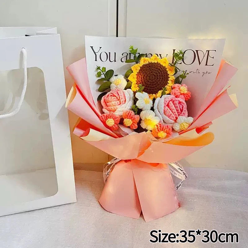 A handmade crochet flower bouquet featuring yellow and pink flowers with a sign that reads You are my love.