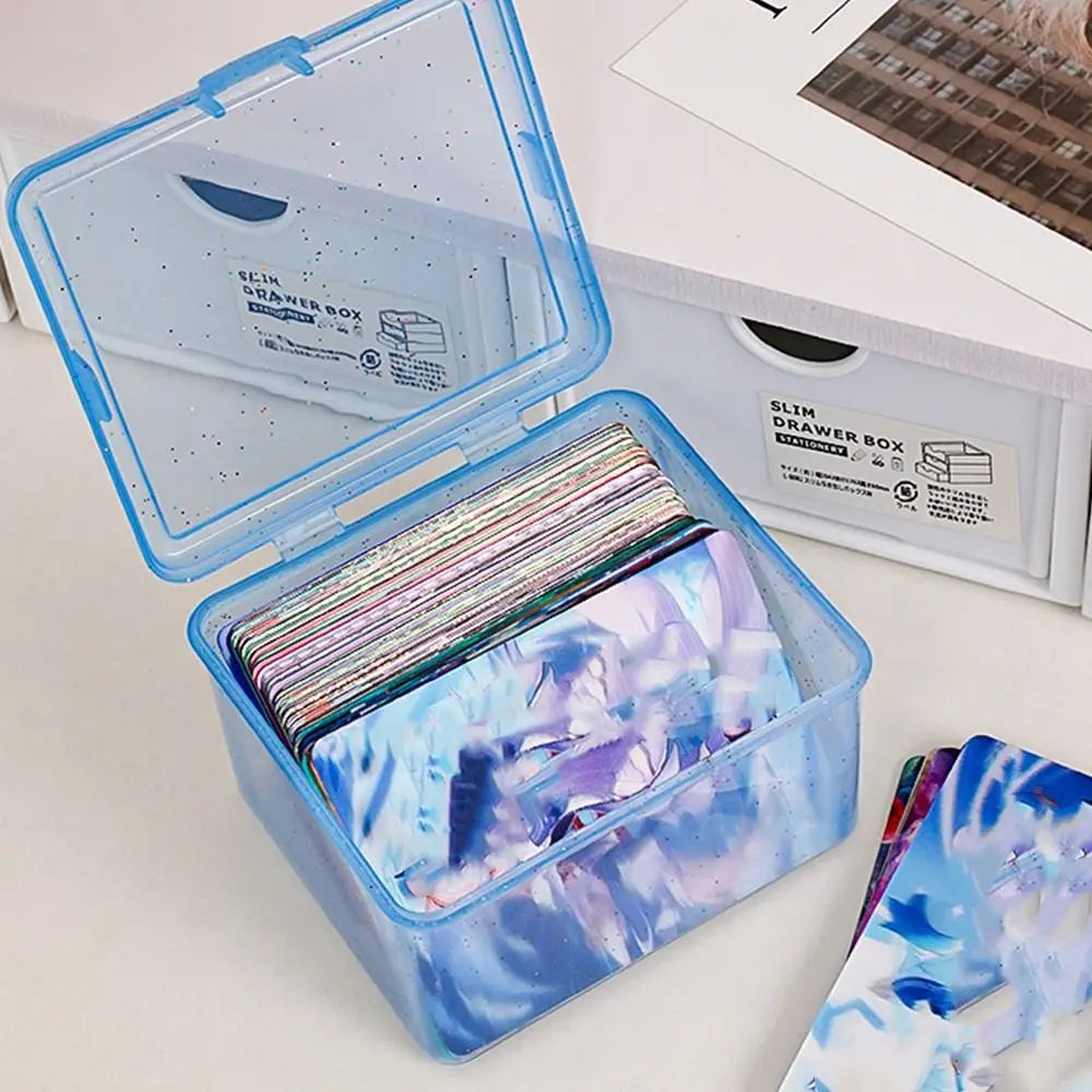 A clear plastic drawer box is open, showing stacked colorful jewelry or small items inside.