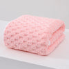 A thick pink microfiber bath towel folded on a white surface.