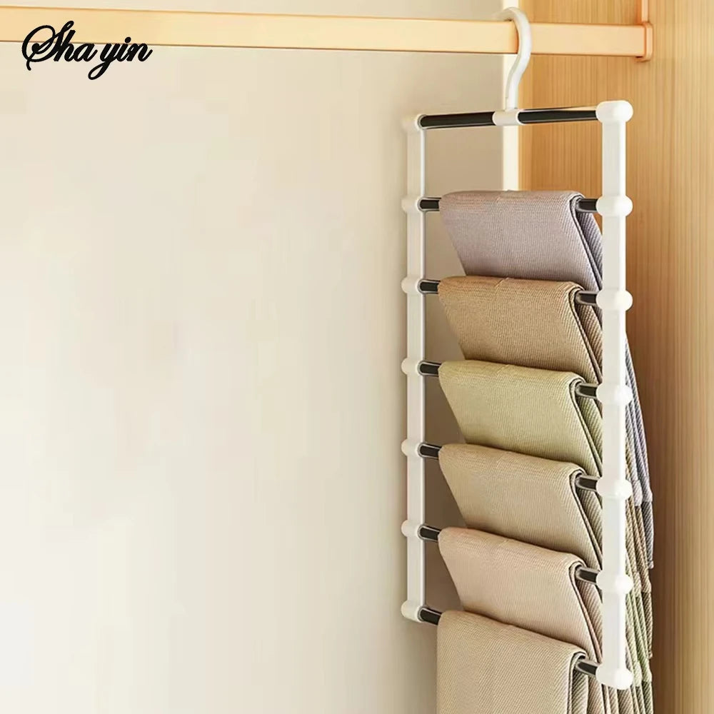 A white multi-layer hanger organizer displaying several folded beige and gray pants on a wooden rack.