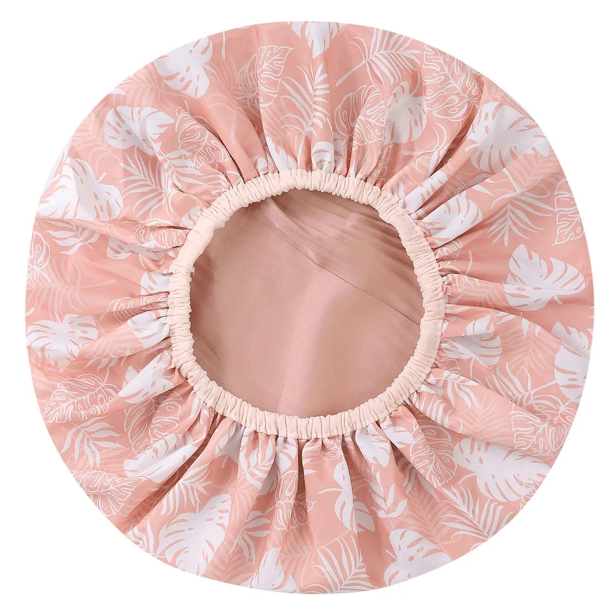 A pink floral patterned reusable satin lined shower cap.