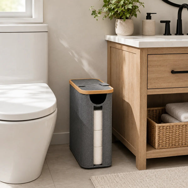 A gray cylindrical storage basket with a lid is placed next to a wooden cabinet and a white toilet.