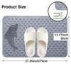 A gray rectangular non-slip bath mat with a dolphin shape molded into the surface and two white flip-flops displayed on it.