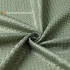 A close-up of a soft, textured, solid green shower curtain fabric with a subtle dotted pattern.