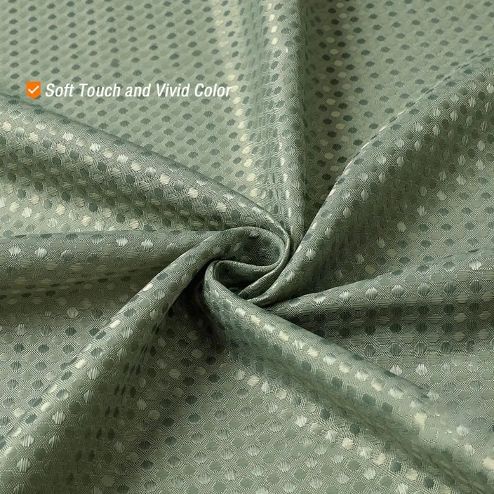 A close-up of a soft, textured, solid green shower curtain fabric with a subtle dotted pattern.