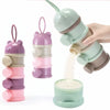 A hand is holding a stack of layered silicone food storage boxes in various shades of purple and green, with some powder spil