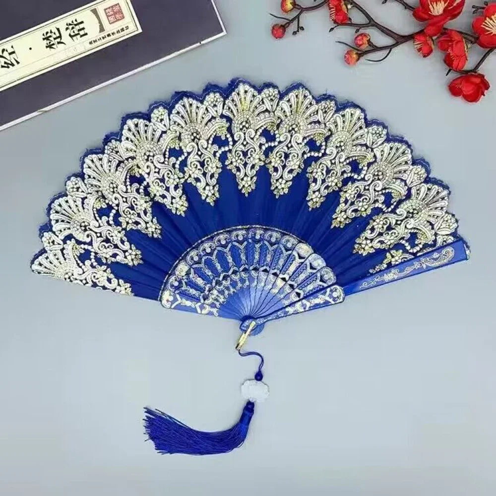 A blue and silver hand folding fan with intricate lace detailing, displayed against a light gray background.